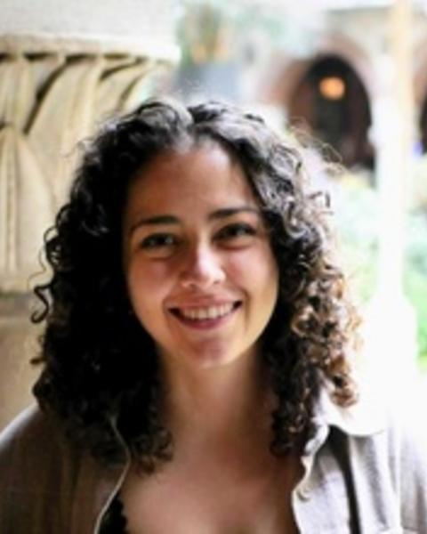person smiling with plants on the background